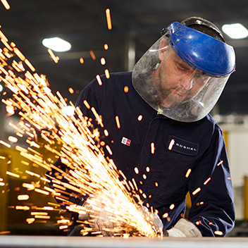 Bucket Image. Man showered by sparks from an angle grinder
