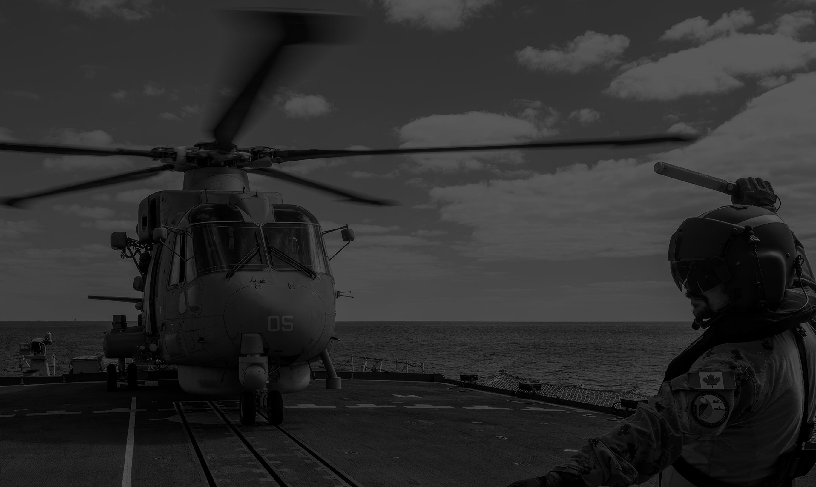 soldier on ship standing by landing helicopter